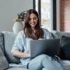 Concentrated,Millennial,Girl,Sit,On,Couch,Working,On,Laptop,Browsing